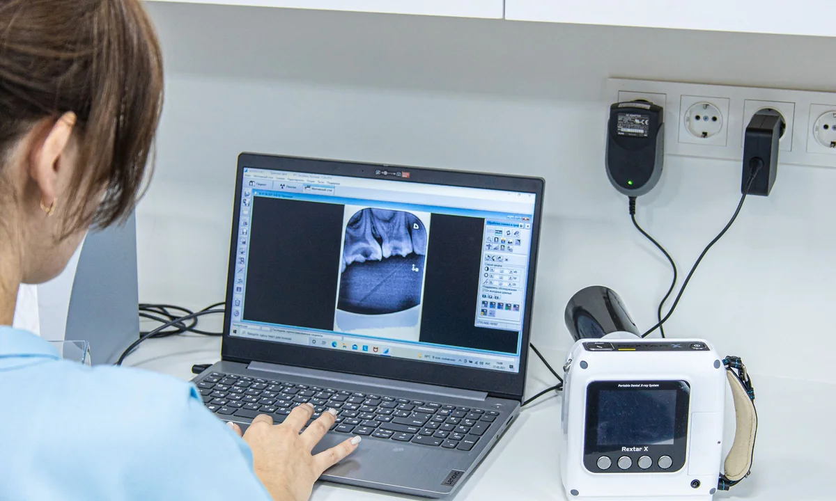 Dental professional reviewing digital imaging on a modern workstation