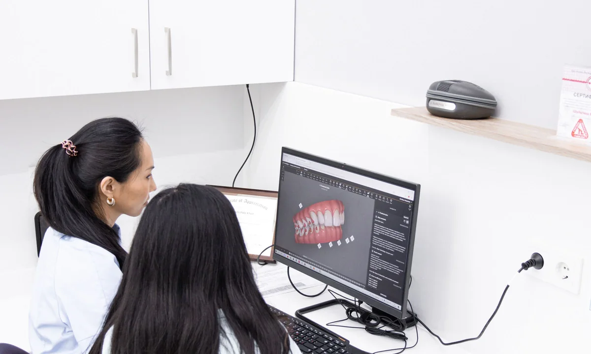 Dental professionals reviewing a three-dimensional teeth model at a workstation